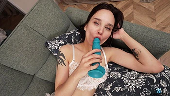 Brunette teen Elly Green masturbates on the sofa with a dildo.